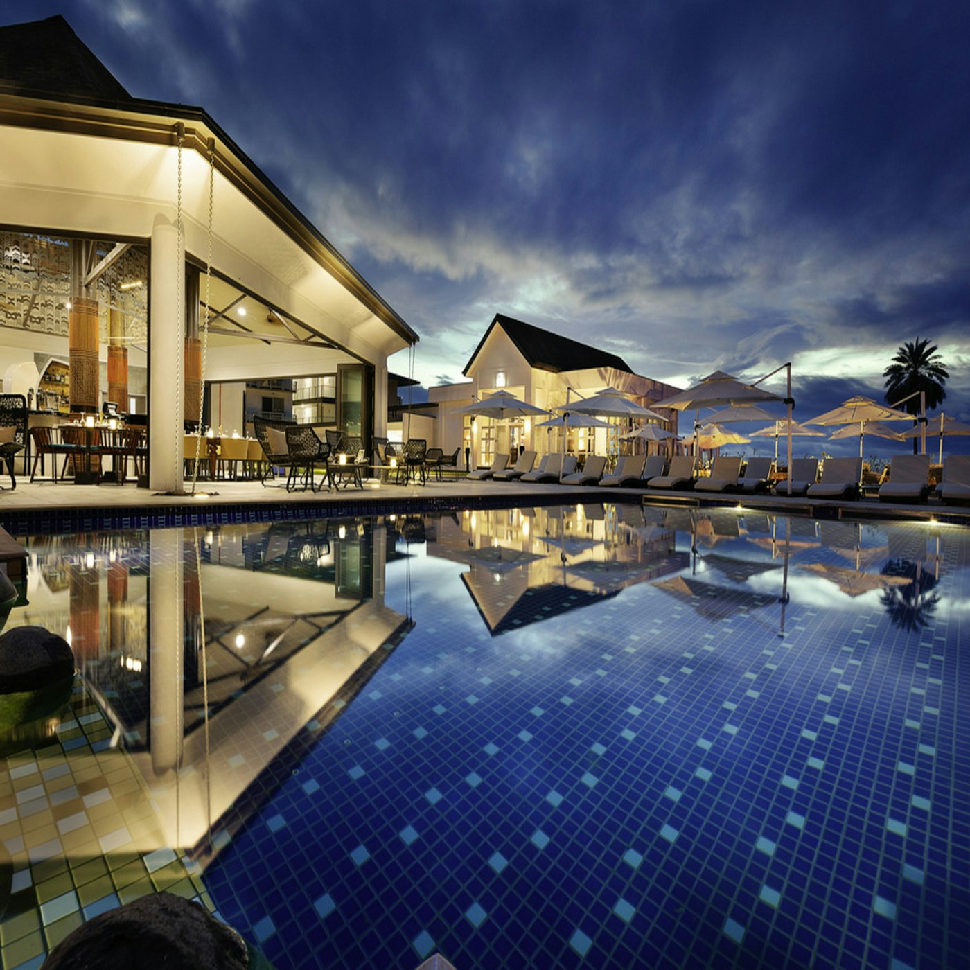 Palm trees and a resort pool beside the ocean